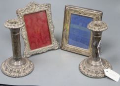 A pair of Edwardian silver candlesticks (a.f.), 17.3cm and two silver mounted photograph frames(a.