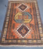 A Caucasian rust ground geometric patterned rug, 172 x 112cm