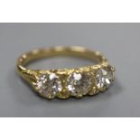 A Victorian style yellow metal and three stone diamond ring with diamond chip spacers, size Q, gross