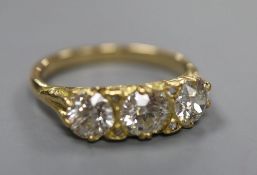A Victorian style yellow metal and three stone diamond ring with diamond chip spacers, size Q, gross