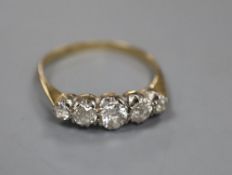 A yellow metal and graduated five stone diamond set half hoop ring, size O, gross 2.1 grams.