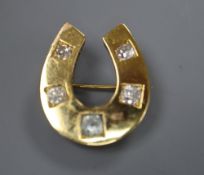 A yellow metal and five stone round cut diamond set horseshoe pendant brooch, 26mm, gross 8.8