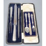 A cased Edwardian silver handled three piece carving set and a cased plated christening trio.