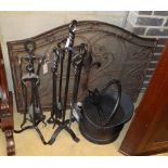 A wrought iron companion set, a coal helmet and a pair of wrought iron and mesh fire guards,