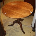 A George III provincial oak tilt top tea table, on three splay legs, 72cm diameter, H.68cm