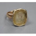 A Victorian yellow metal and intaglio citrine? ring, carved with a family crest (stone chipped),
