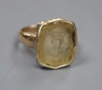 A Victorian yellow metal and intaglio citrine? ring, carved with a family crest (stone chipped),