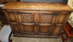 An 18th century style linen fold moulded oak two door cabinet, W.150cm, D.39cm, H.107cm