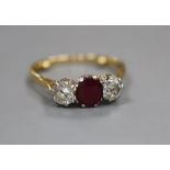 An 18ct and plat, ruby and diamond set three stone ring, size M/N, gross 3 grams.