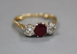 An 18ct and plat, ruby and diamond set three stone ring, size M/N, gross 3 grams.