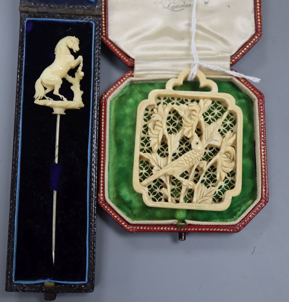 A carved ivory 'rearing horse' stick pin and a carved ivory panel pendant? 55mm.