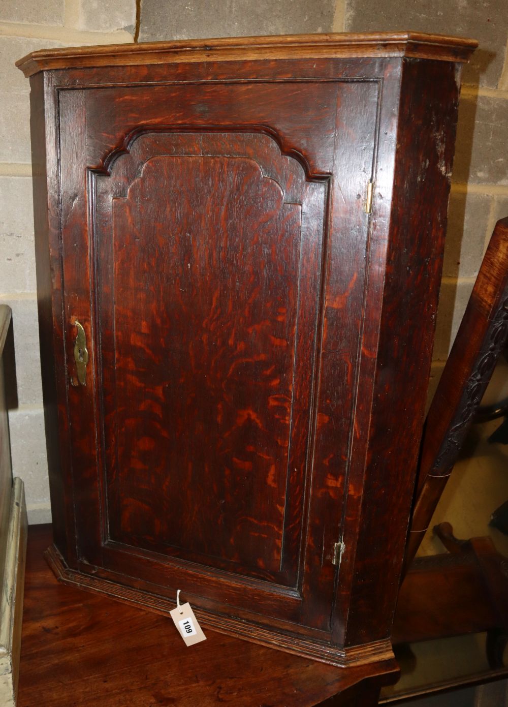 A George III oak hanging corner cupboard, W.68cm, D.38cm, H.90cm