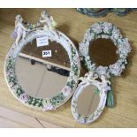 A Sitzendorf porcelain floral encrusted oval mirror and two smaller similar mirrors, tallest 33cm