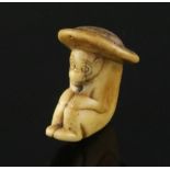 An 18th century Japanese stag horn netsuke of a monkey wearing a broad rimmed hat, depth 4cm