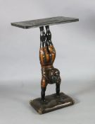 A 20th century carved and painted wood occasional table, with faux marble top, blackamoor acrobat