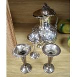 Three George V silver spill vases, height 11cm and a Victorian silver plated water jug