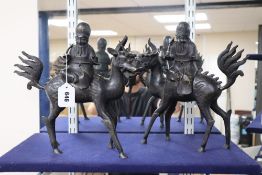 A pair of Chinese bronze incense burners and covers, each modelled as Shou Lao seated on a qilin,