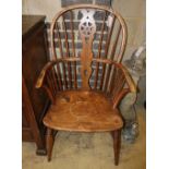 An early 19th century elm and ash wheel back elbow chair