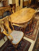 A Queen Anne style burr walnut extending dining table and a set of six matching chairs with