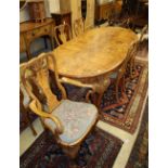 A Queen Anne style burr walnut extending dining table and a set of six matching chairs with