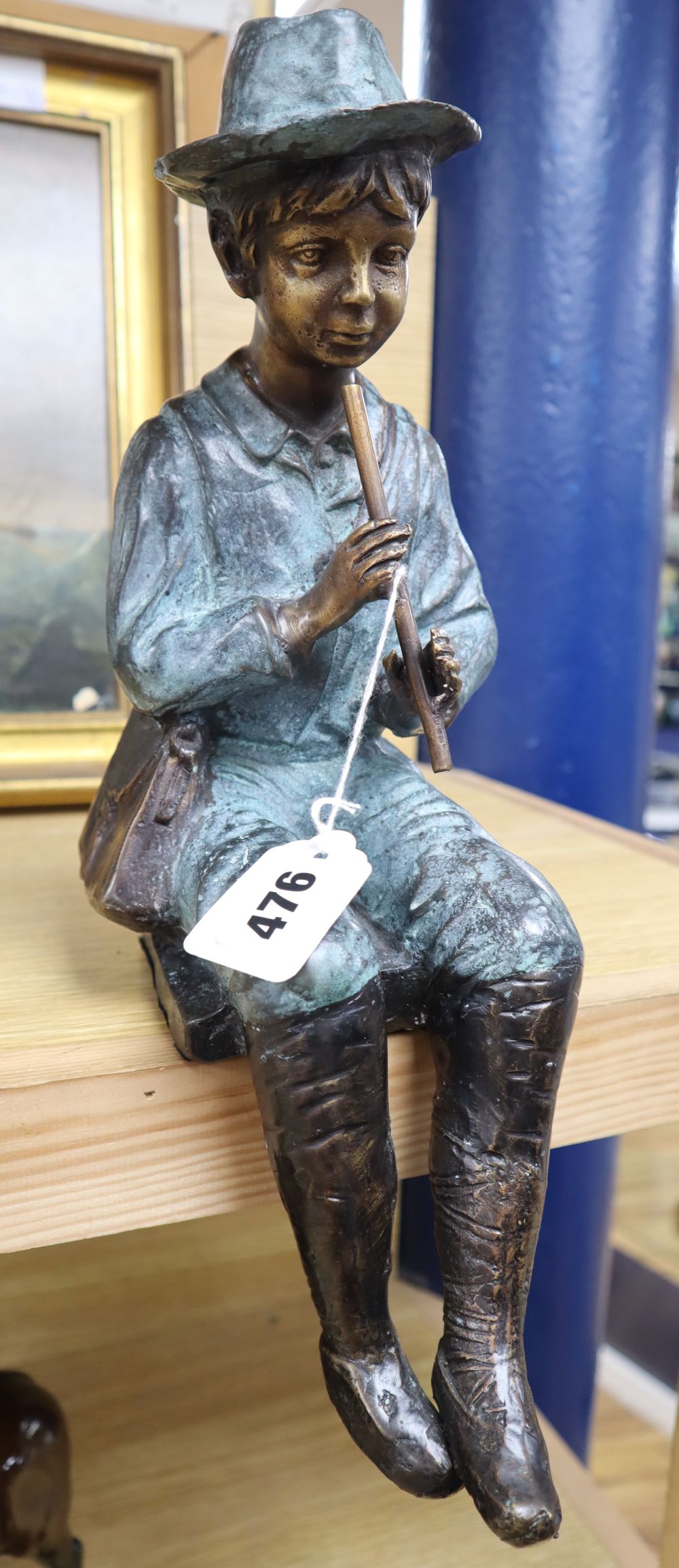A 20th century patinated bronze of a seated boy with a pipe, height 35cm
