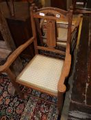 A pair of Arts and Crafts oak elbow chairs
