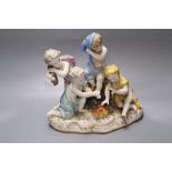 A 19th century German porcelain figure group of four semi-draped youths beside a fire, width 21cm