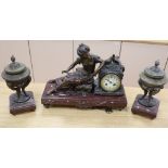 An early 20th century spelter clock garniture, on rouge marble plinths, clock width 44cm