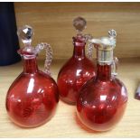 Three Victorian cranberry glass claret jugs