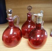 Three Victorian cranberry glass claret jugs
