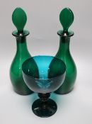 A pair of late Georgian green glass decanters and stoppers, height 27cm and a similar rummer