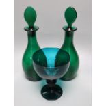 A pair of late Georgian green glass decanters and stoppers, height 27cm and a similar rummer