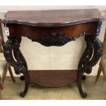 A Victorian carved walnut serpentine front two tier console table with hinged top, width 98cm, depth