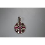 An early 20th century white and yellow metal, ruby and diamond set pierced circular pendant, 20mm,