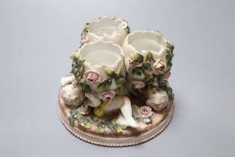 A Sitzendorf trio of vases, supported by floral encrusted putti, diameter 13cm