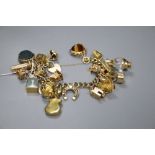 A 9ct gold charm bracelet, hung with twenty two assorted charms including 9ct gold, gross 117.5