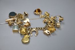 A 9ct gold charm bracelet, hung with twenty two assorted charms including 9ct gold, gross 117.5