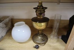 A brass oil lamp, with opaque glass shade