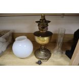 A brass oil lamp, with opaque glass shade