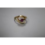 A modern 18ct gold, single stone ruby and four stone diamond set crossover ring, size L, gross 3.5