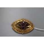 A Victorian yellow metal and garnet set navette shaped brooch, 52mm, gross 14.9 grams.CONDITION: