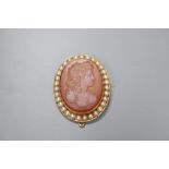 A yellow metal and split pearl set oval hardstone cameo pendant brooch, carved with the bust of a