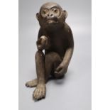 A Japanese stoneware figure of a monkey holding a peach, height 17cm