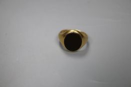 A 1920's 18ct gold and brown chalcedony? set oval signet ring, size M, gross 6.4 grams.CONDITION:
