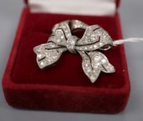 A white metal and diamond set bow brooch, 28mm, gross 5.7 grams and a 9ct and plat, three stone