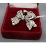 A white metal and diamond set bow brooch, 28mm, gross 5.7 grams and a 9ct and plat, three stone