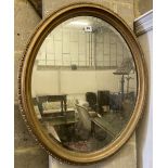 An early 20th century oval giltwood and gesso wall mirror, width 60cm height 70cm