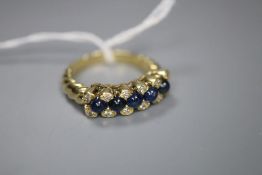A modern 750 yellow metal, cabochon sapphire and diamond set half hoop dress ring, with spiral twist