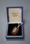 An Edwardian yellow metal and seed pearl mounted hardstone cameo pendant brooch, carved with the