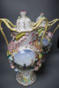 A pair of floral encrusted two handled and lidded vases